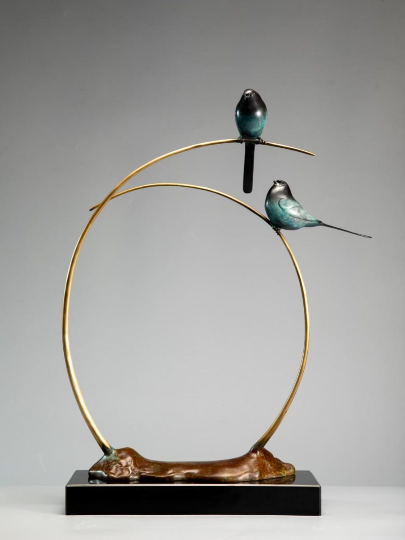 Two little birds stand on the branch