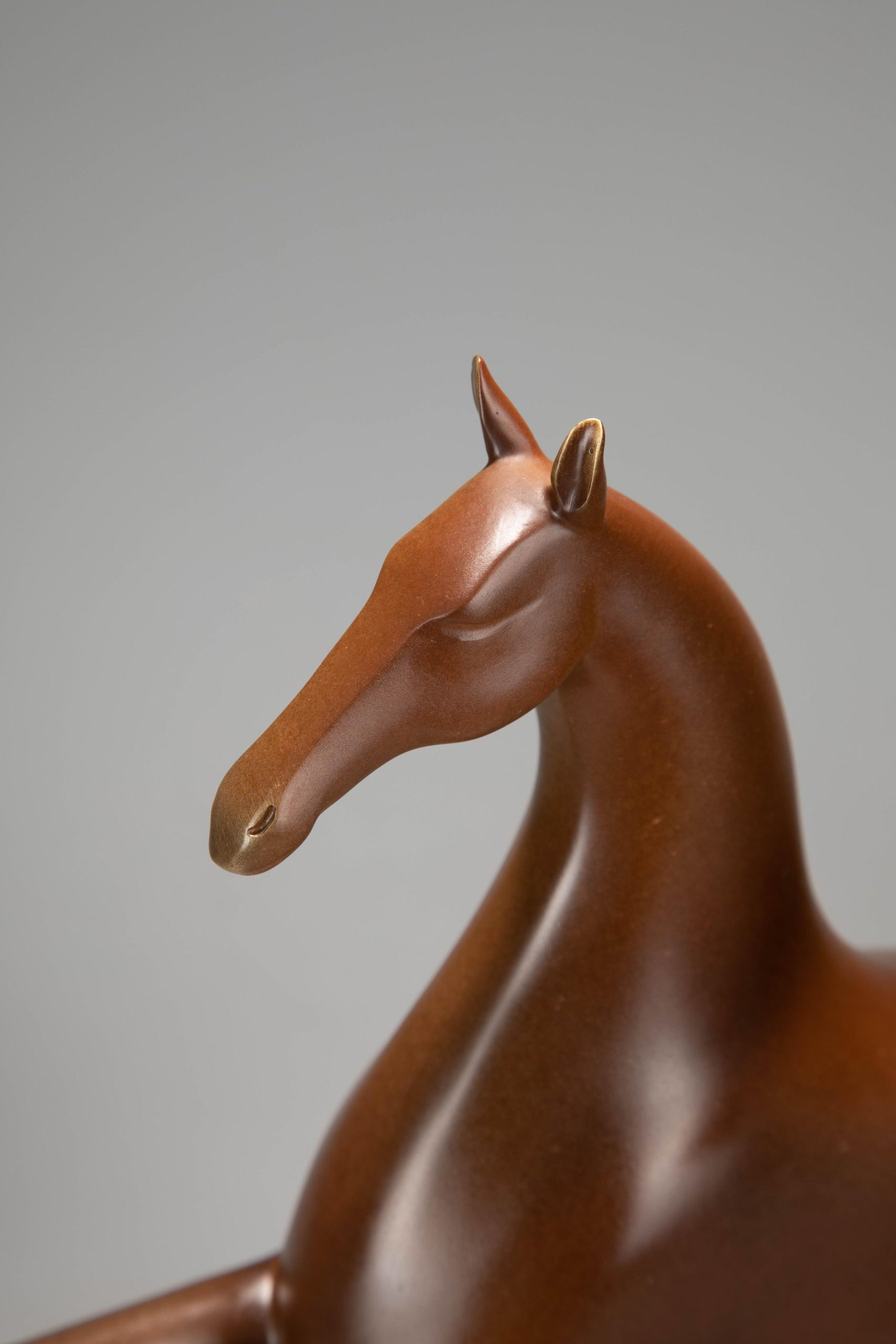 Running horse pair in warm sienna — head close-up.