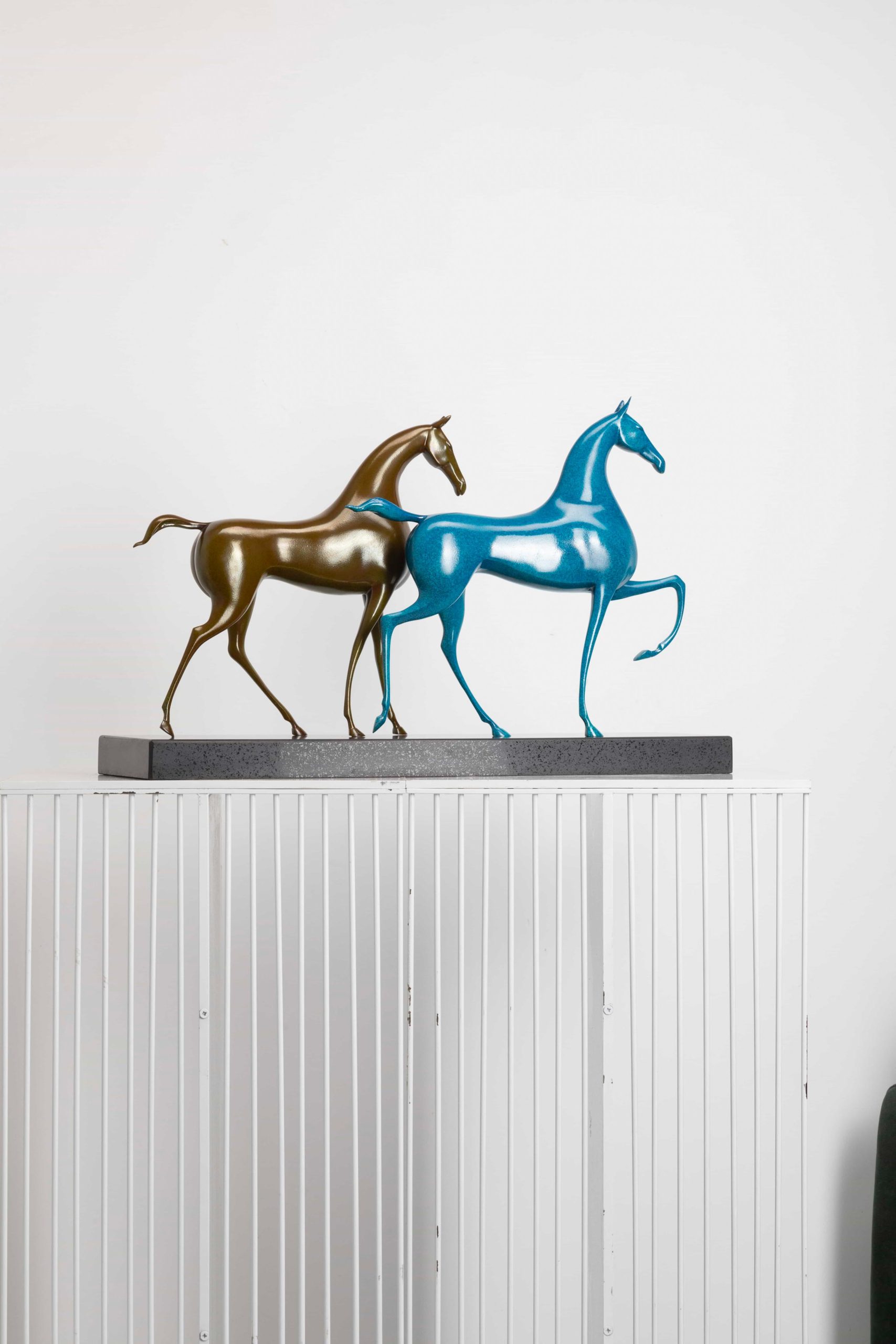 Running horse pair in turquoise and gold — opposite three-quarter.