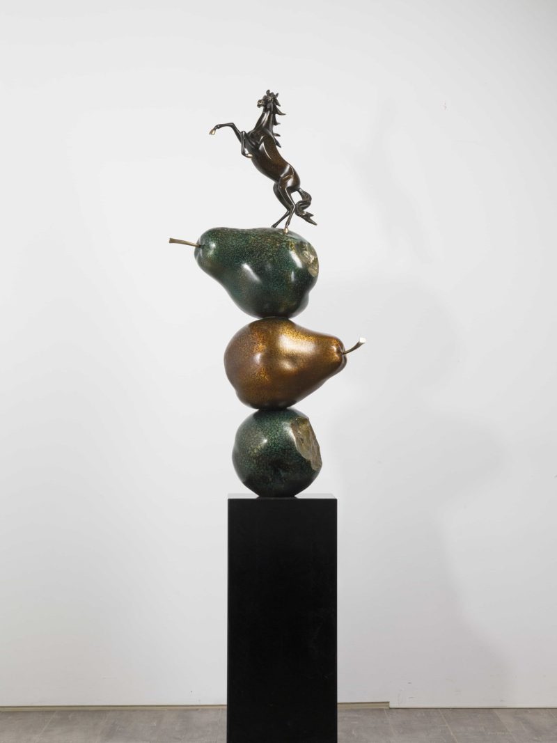 The horse stood on top of three pears.