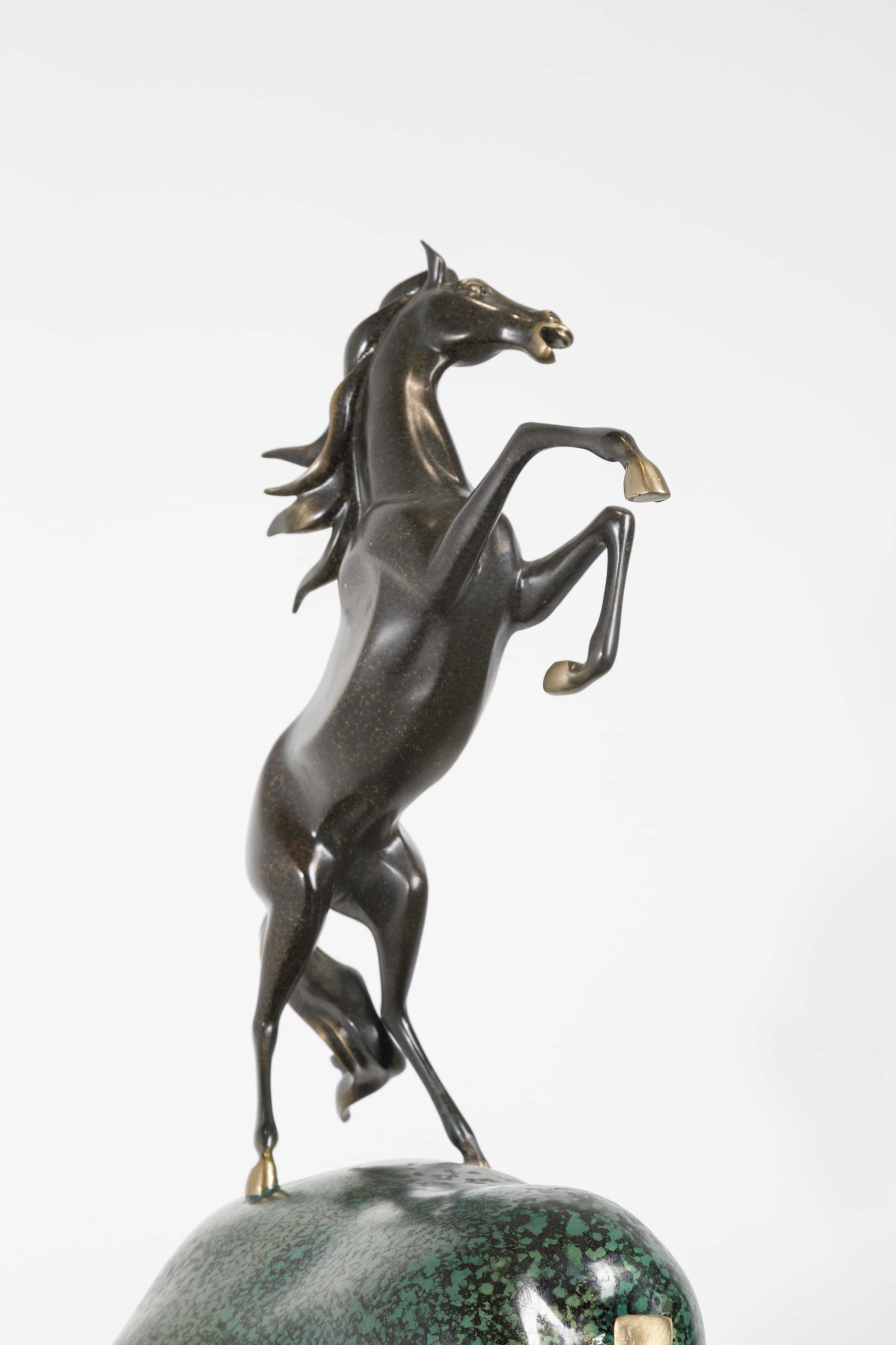 Dark bronze rearing horse atop stacked pears — horse close-up.
