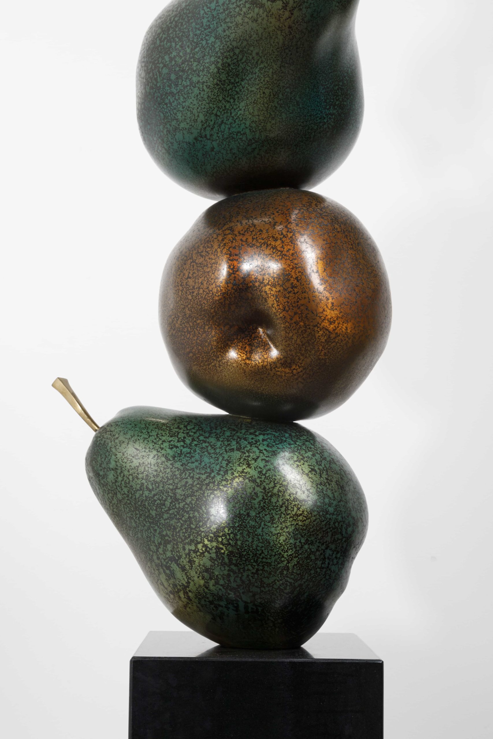 Dark bronze rearing horse atop stacked pears — pear stack close-up.