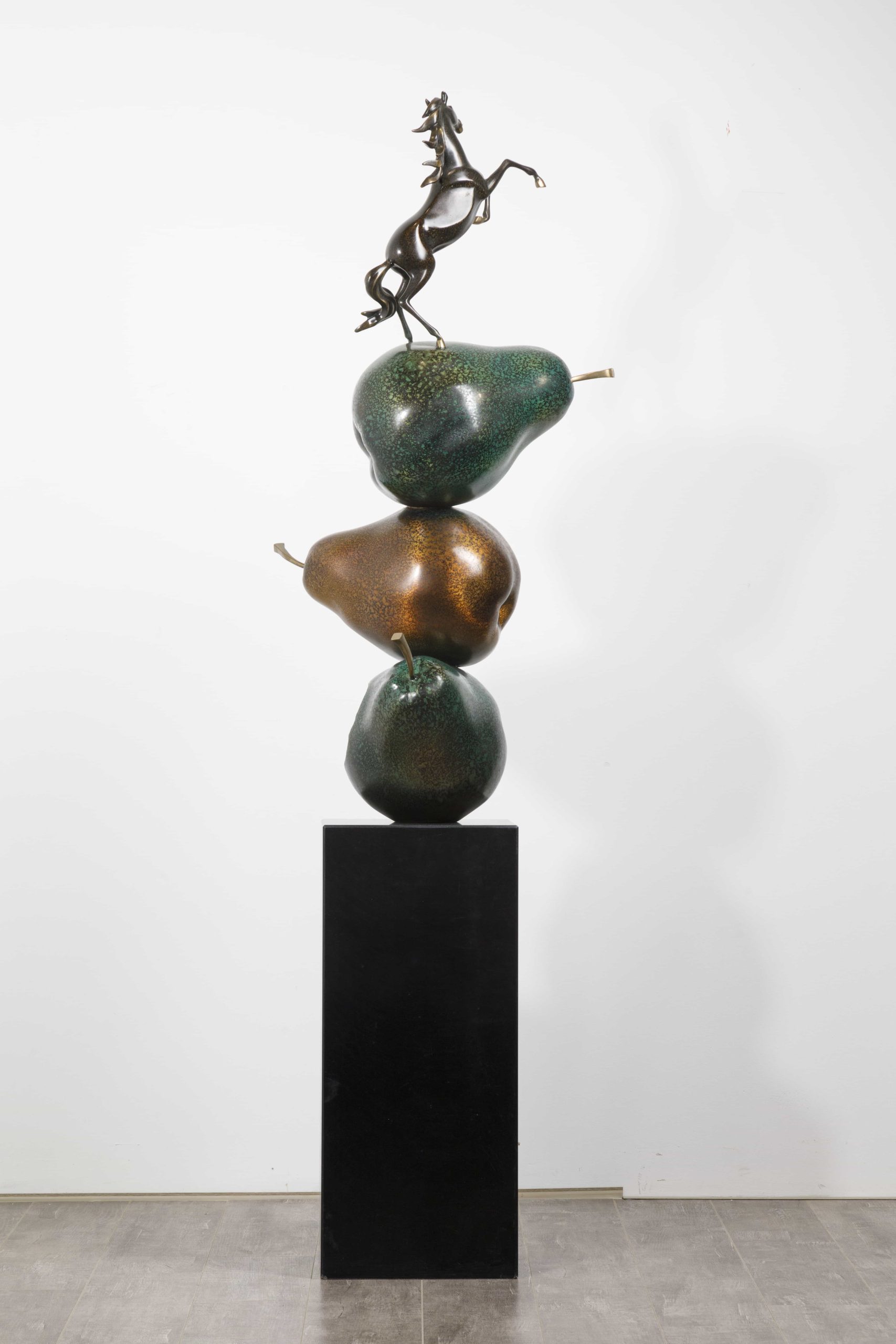 Dark bronze rearing horse atop stacked pears — straight-on view.