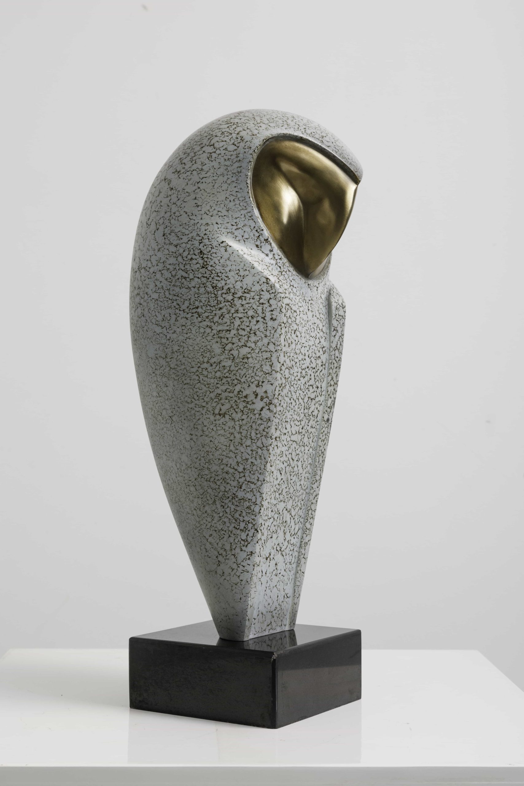 Speckled owl with brass heart-shaped face — opposite three-quarter.