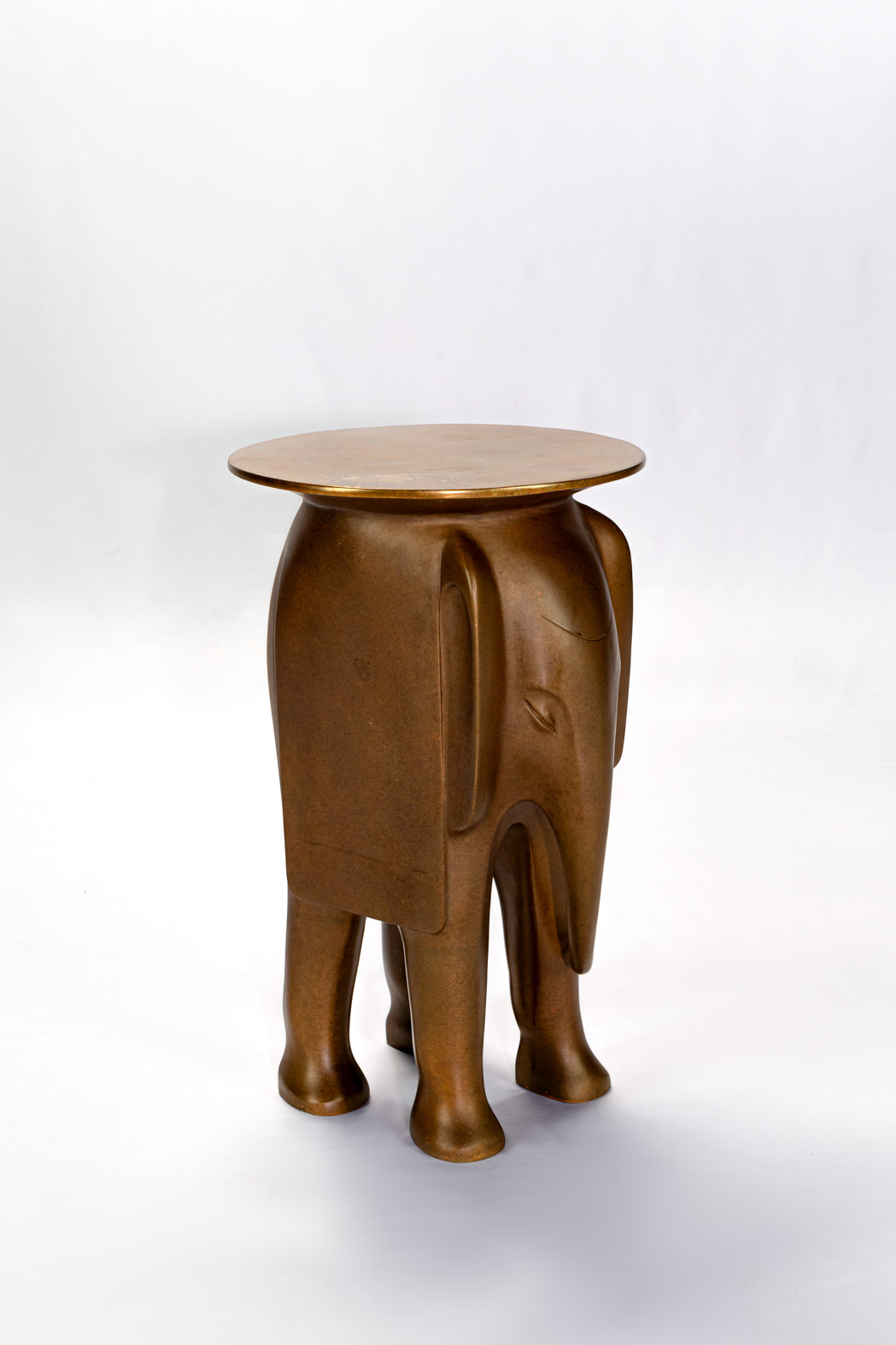 Three-quarter view of the minimalist bronze elephant side table