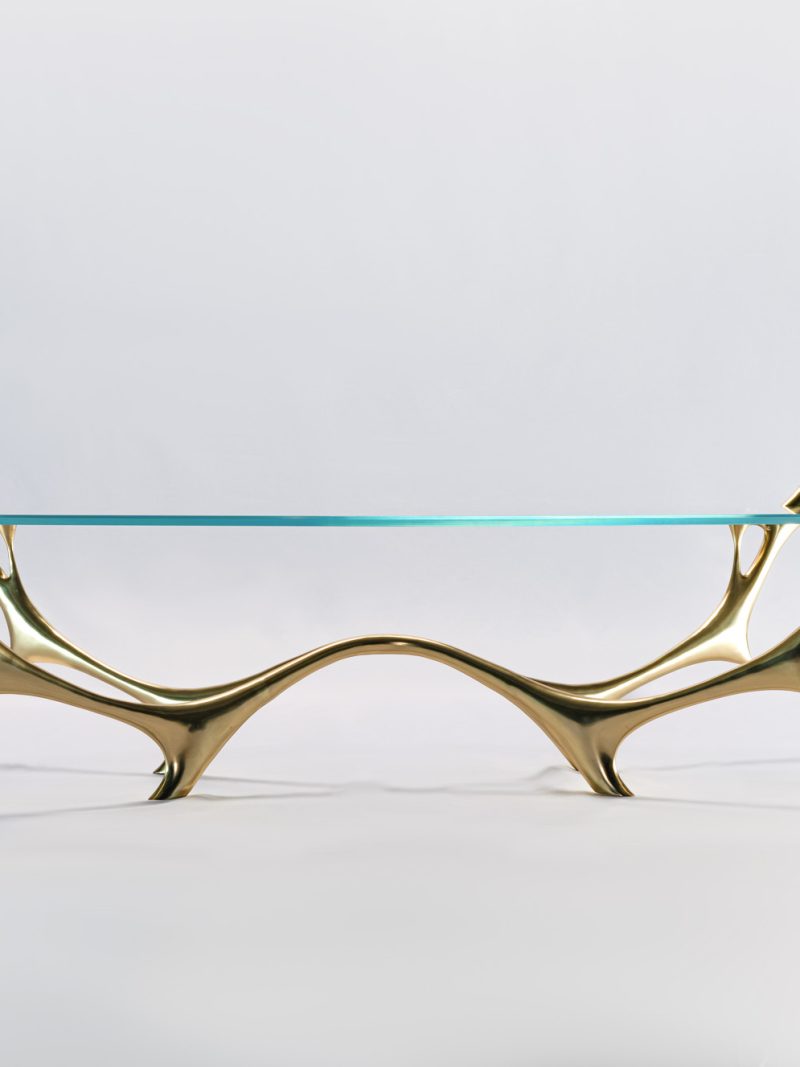 Abstract water-and-branch form bronze coffee table with oval glass top, three-quarter view