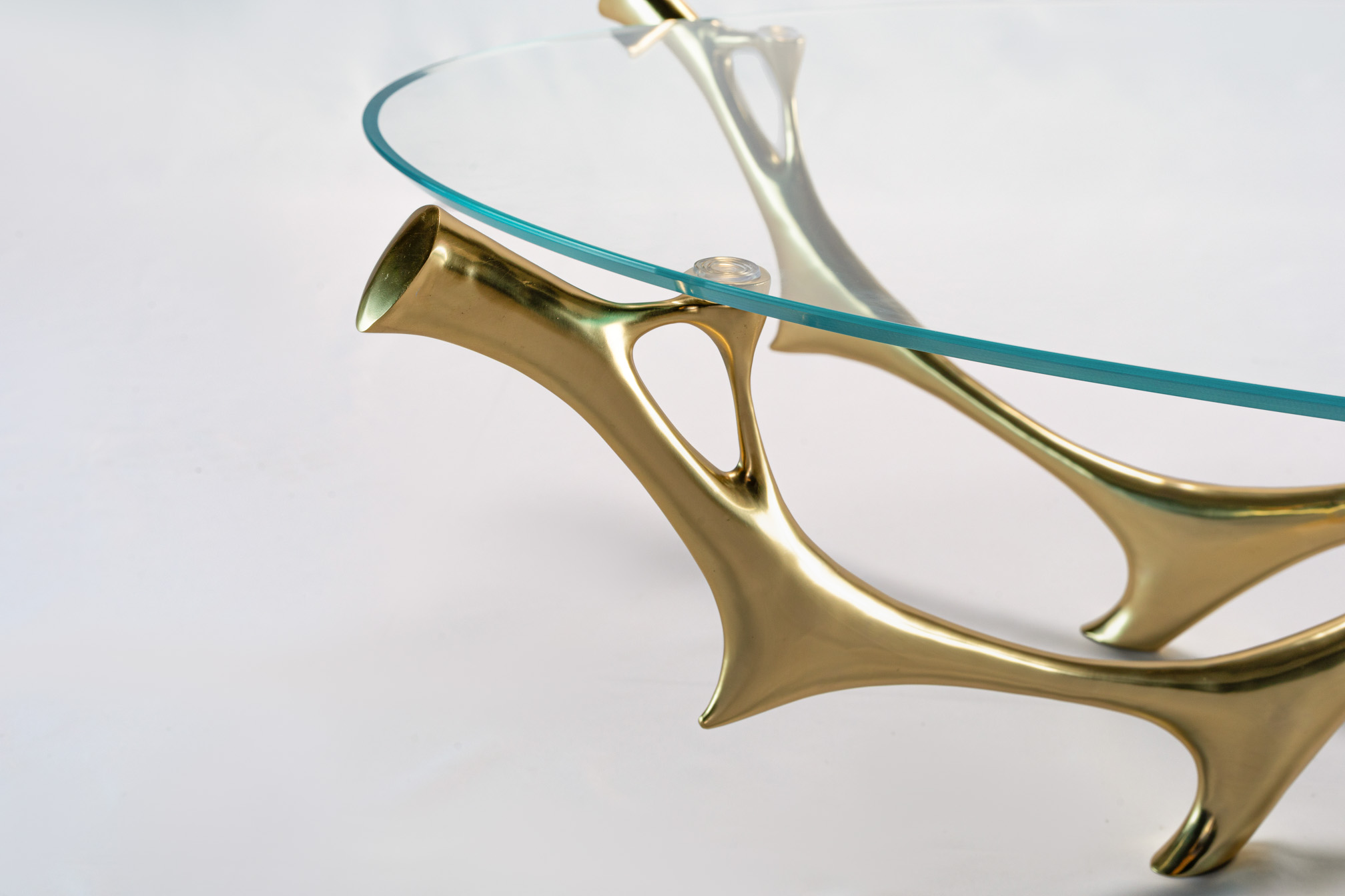 Detail of the cast bronze branch meeting the corner of the glass top