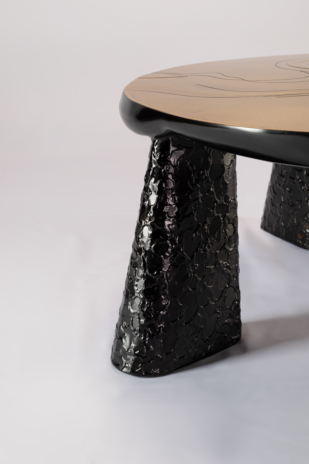 Close-up of the black hammered cone leg of the bronze coffee table