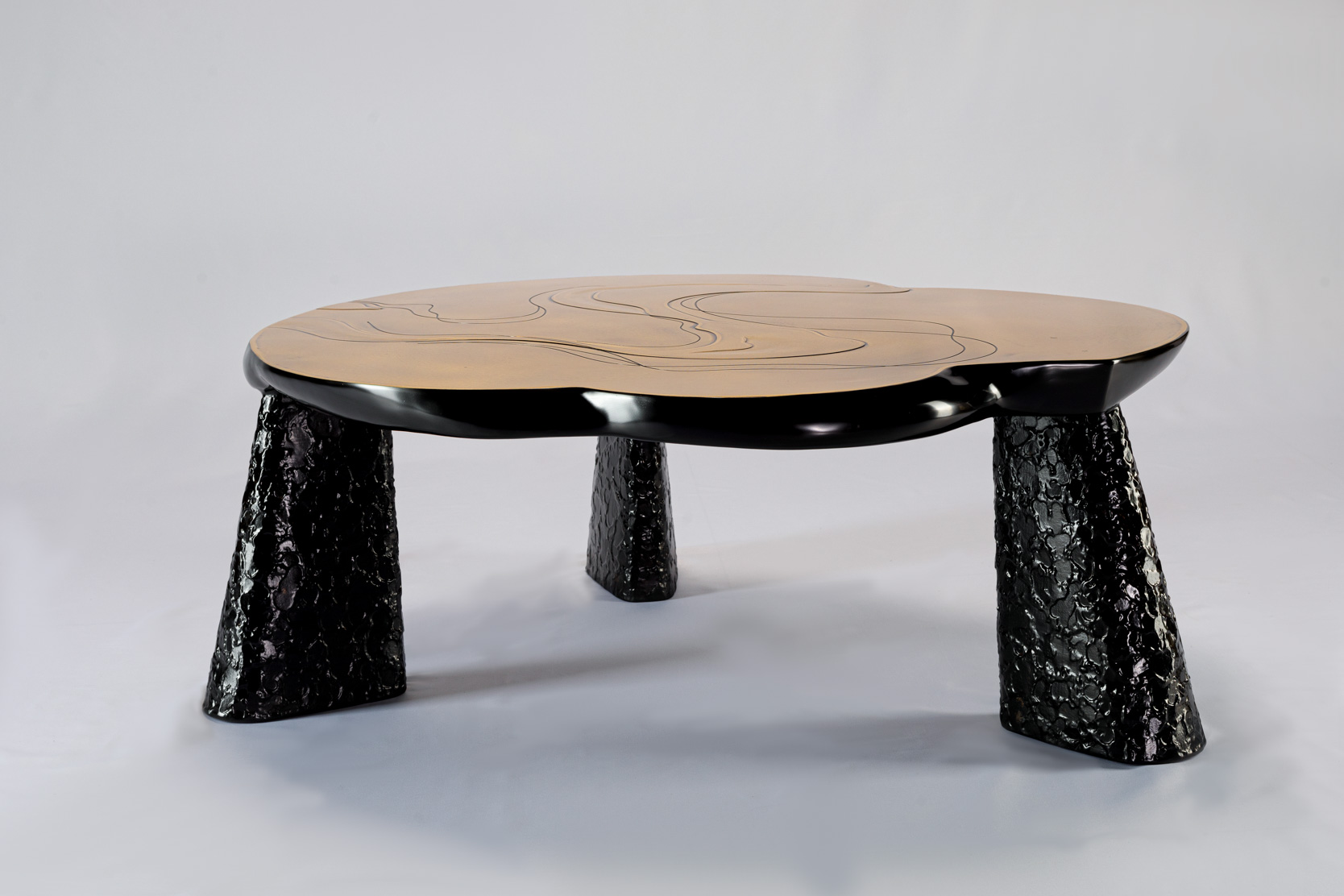 Champagne-toned bronze coffee table with engraved ripple lines, side view