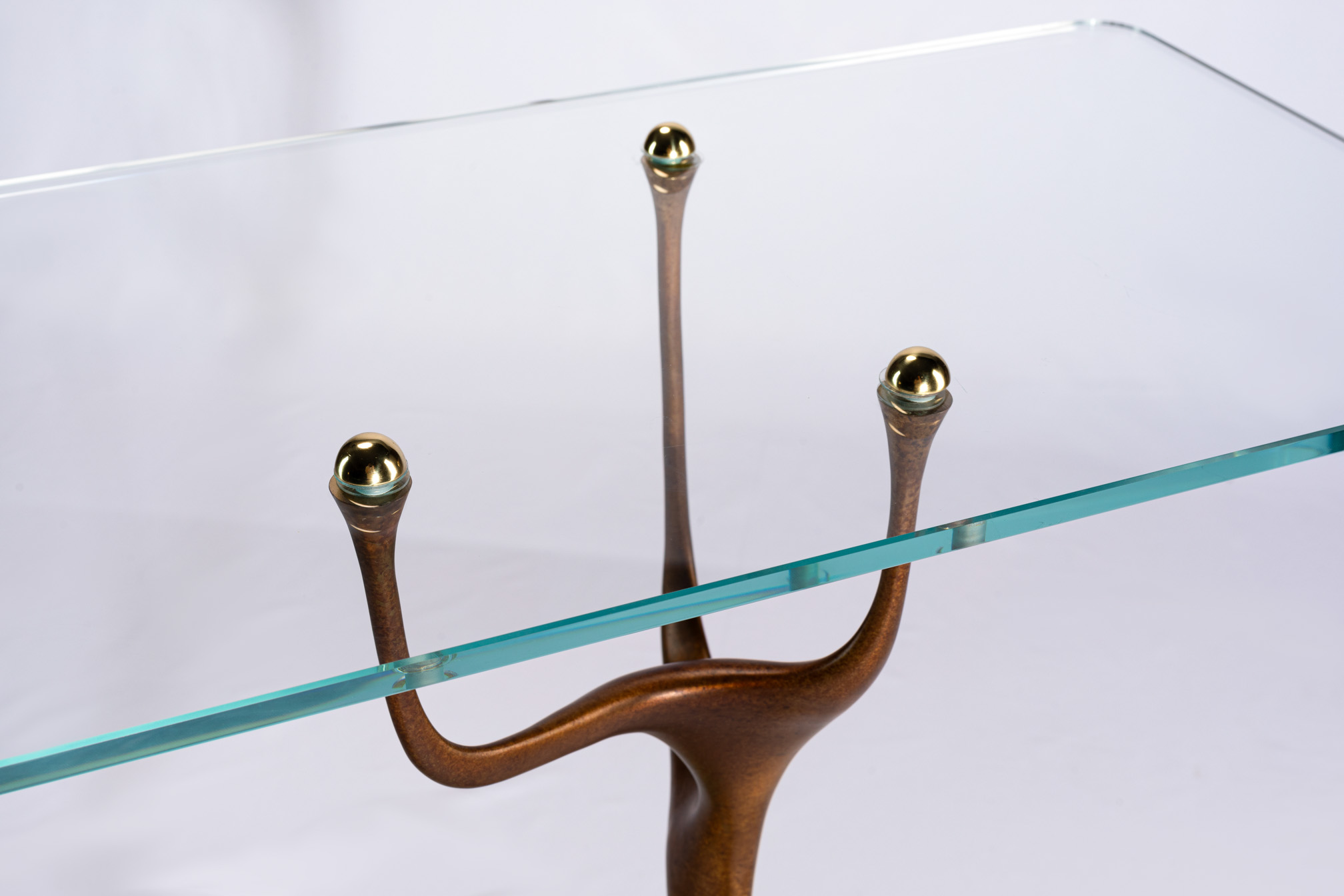 Close-up of the bronze antler tips and brass ball finials under the glass top