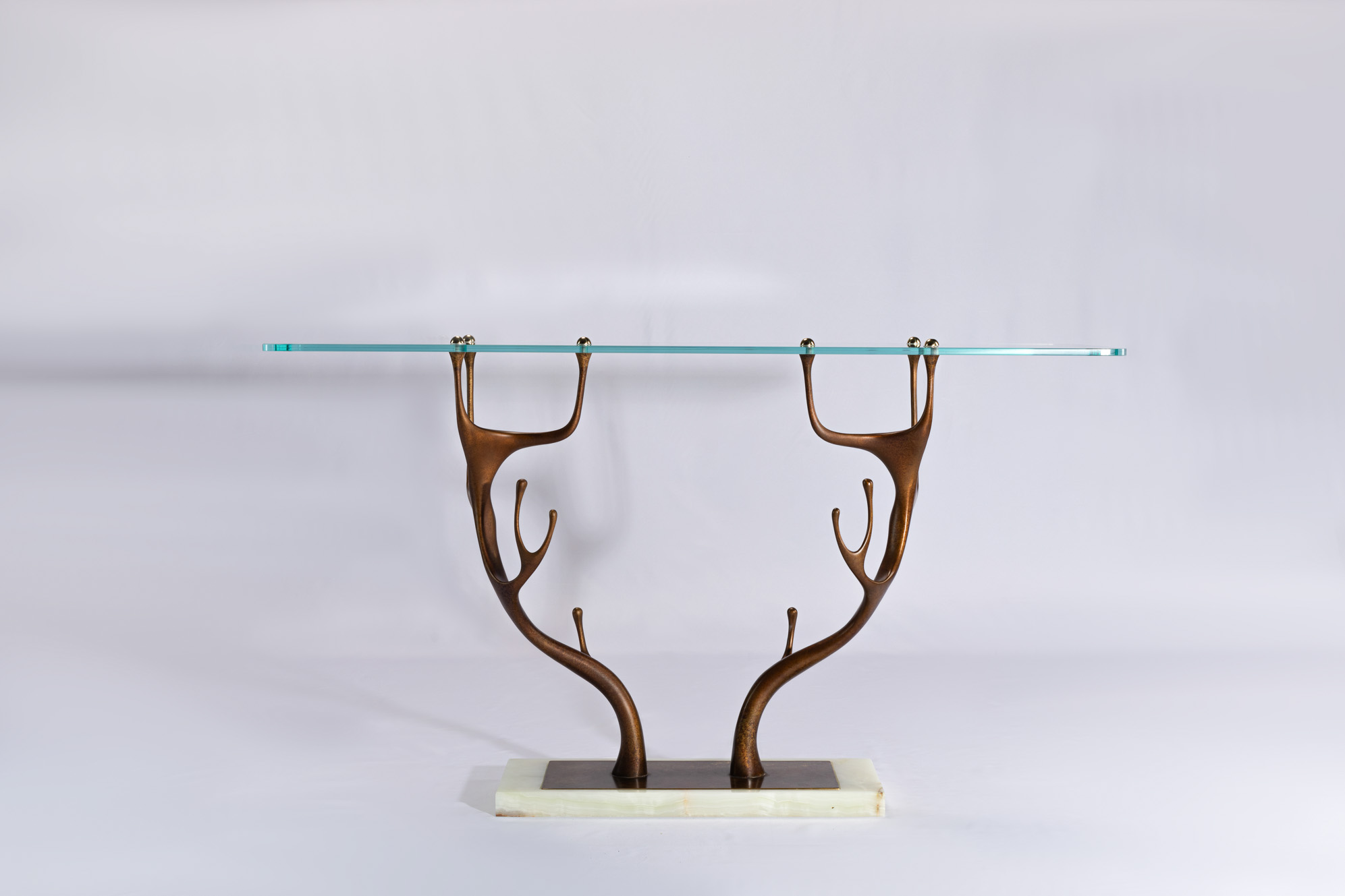 Deer antler bronze console table with clear glass top and stone base, front view