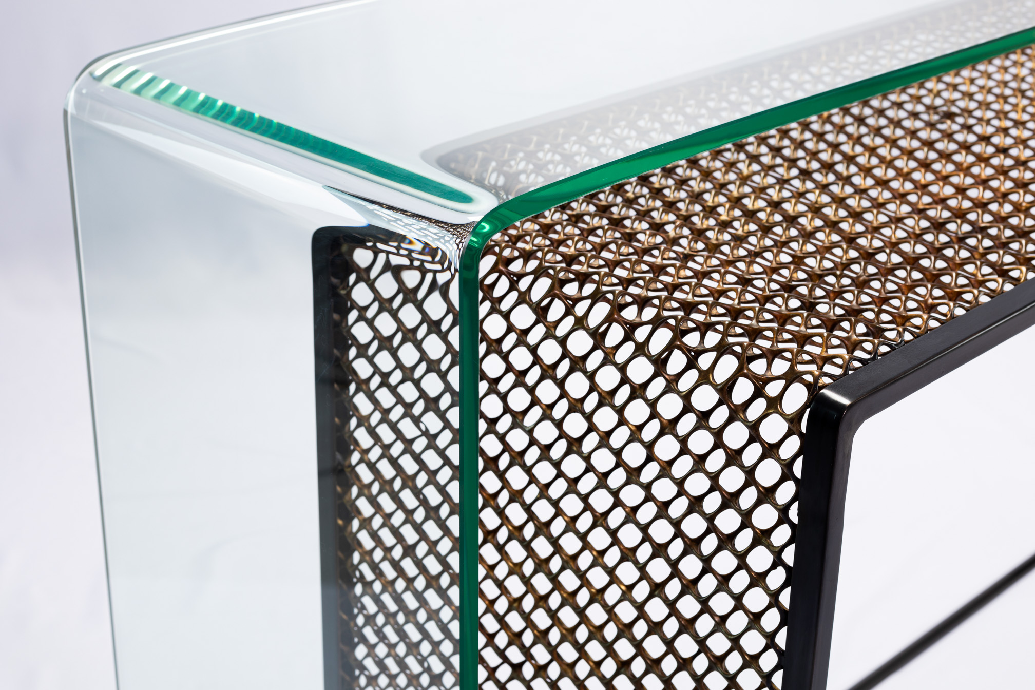 Close-up of the curved glass edge over the woven bronze mesh body