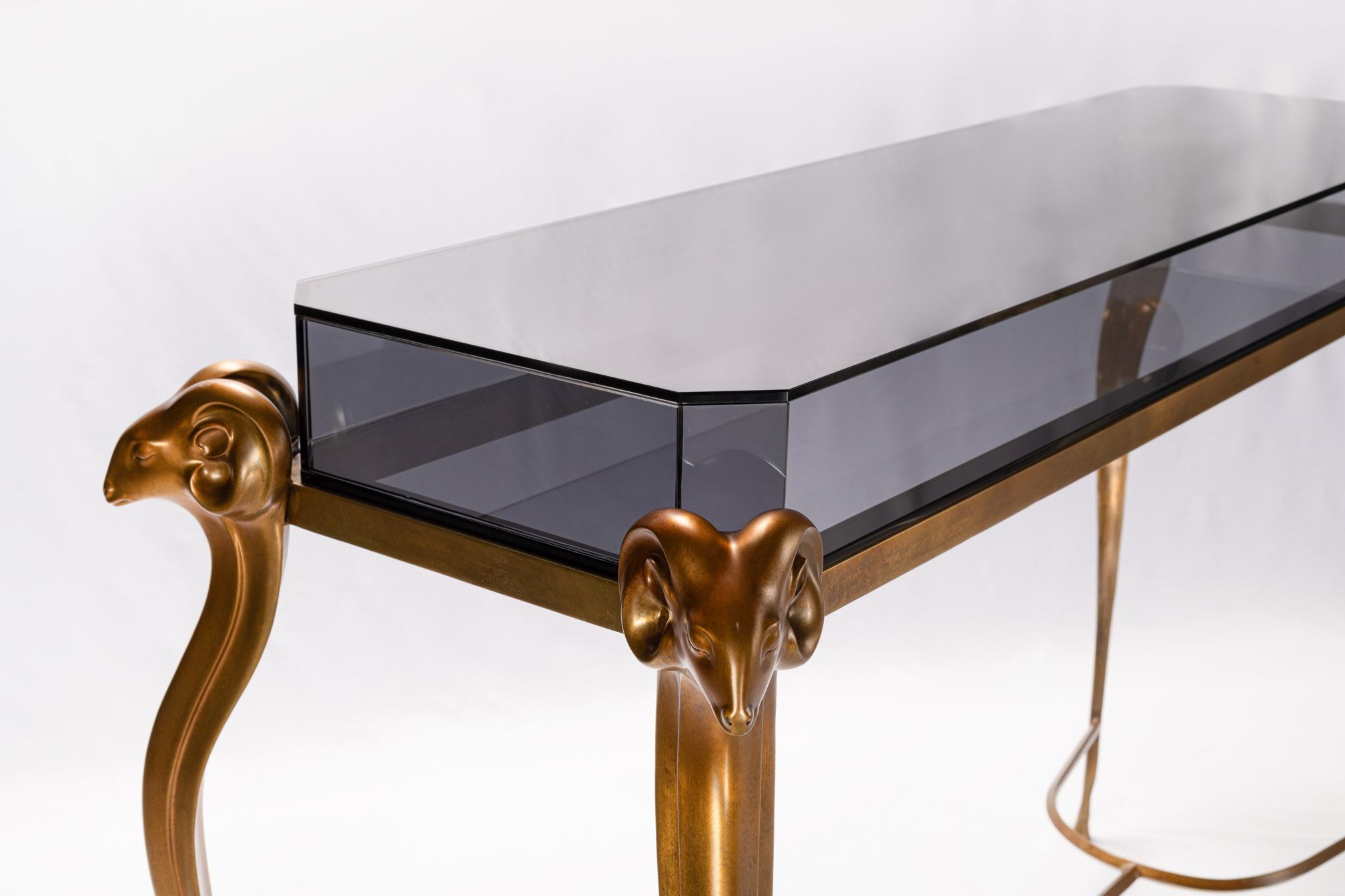 Detail of the bronze leg top meeting the smoked glass top