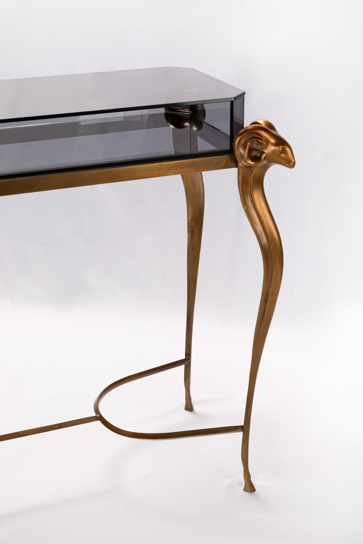 Detail of the curved bronze stretcher of the antelope console table