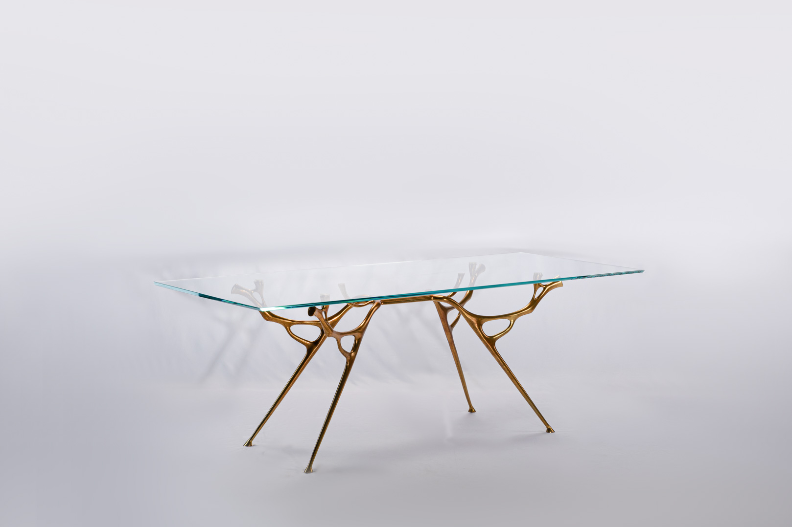 Straight-on view of the bronze dining table with glass top