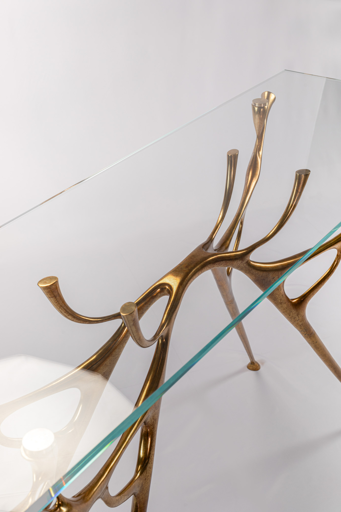 Angled view of the bronze console table showing the water-and-branch base