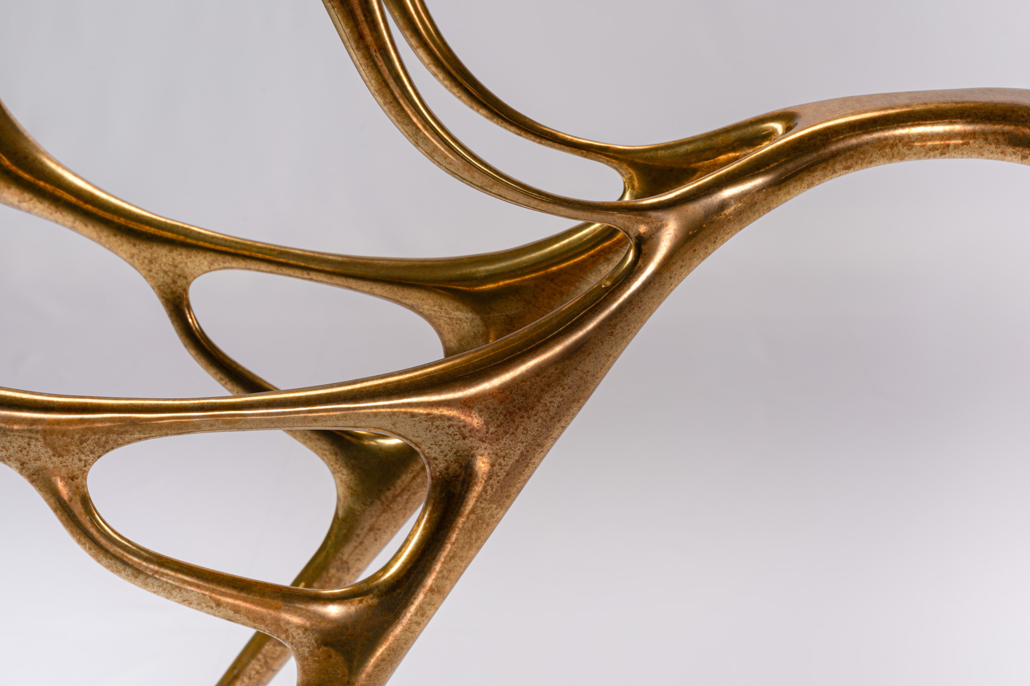 Close-up of the water-and-branch bronze form of the console base