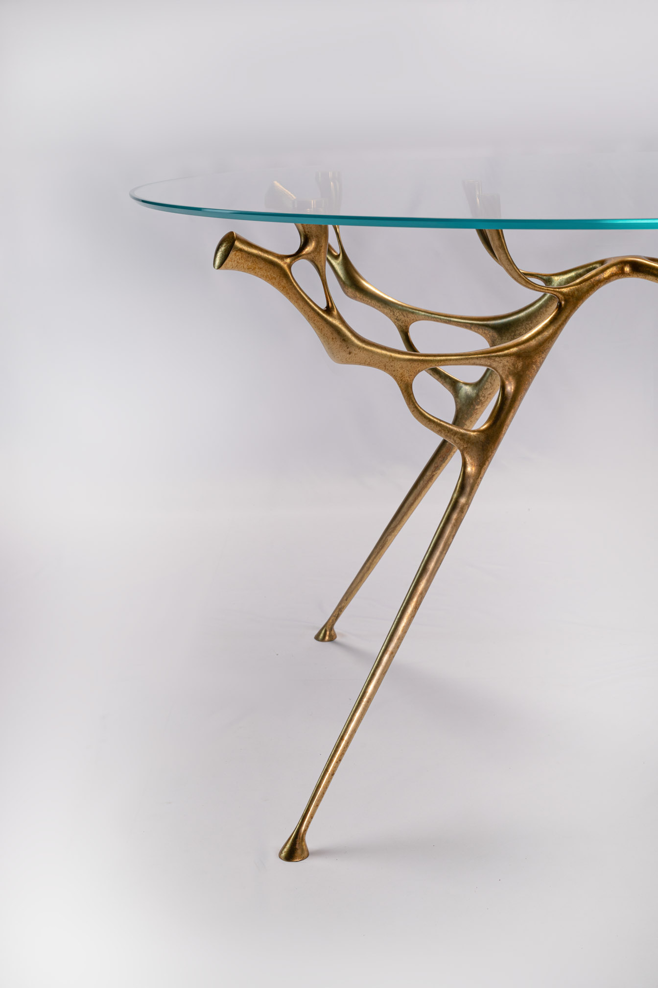 Three-quarter view of the round bronze dining table