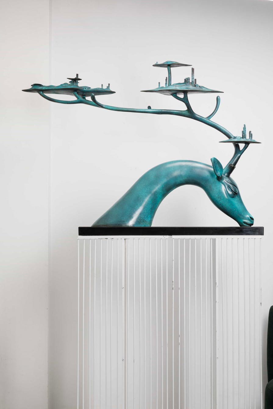 Large teal patina deer with tree-canopy antlers — front view.