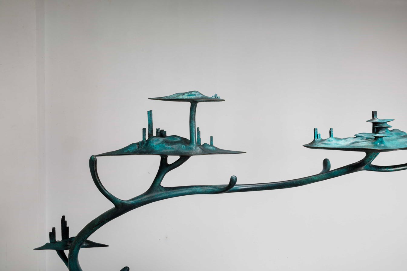 Large teal patina deer with tree-canopy antlers — branch canopy detail.