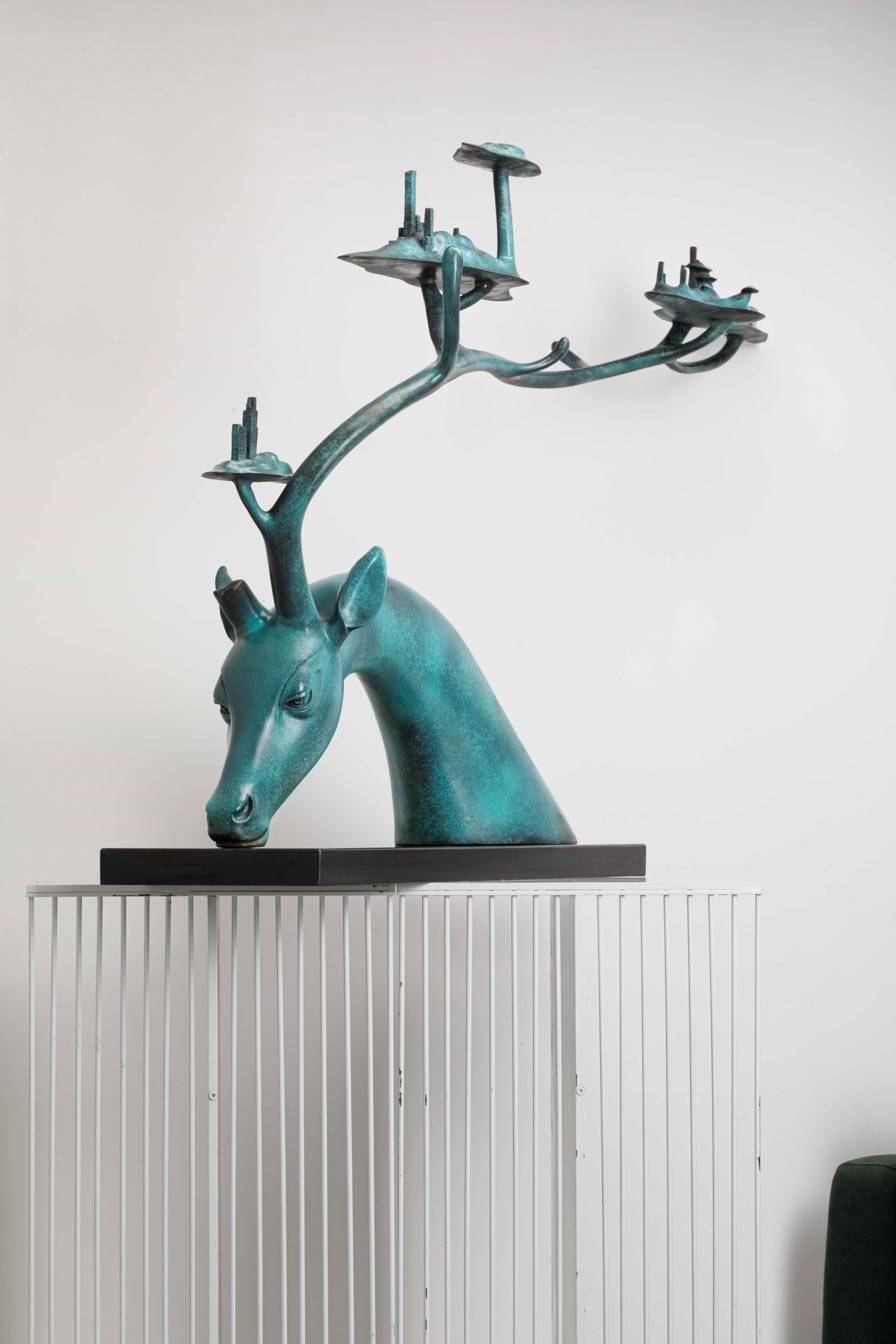 Large teal patina deer with tree-canopy antlers — side full view.