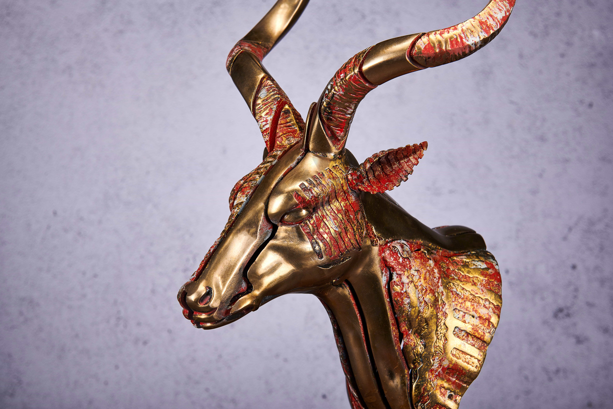 Deconstructed antelope bust in gold and coral — head close-up.