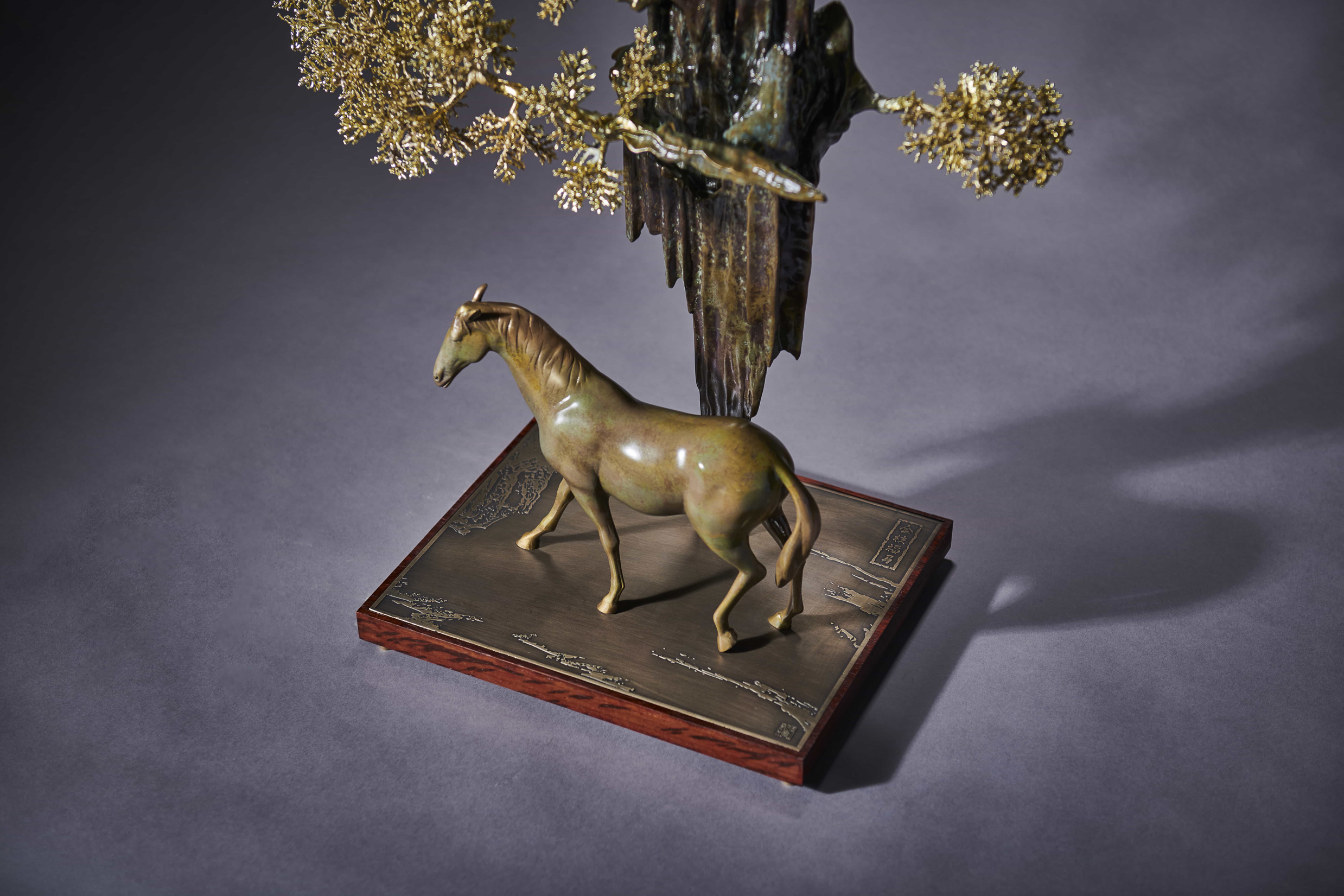 Horse beneath golden-leaf rockery — alt angle.