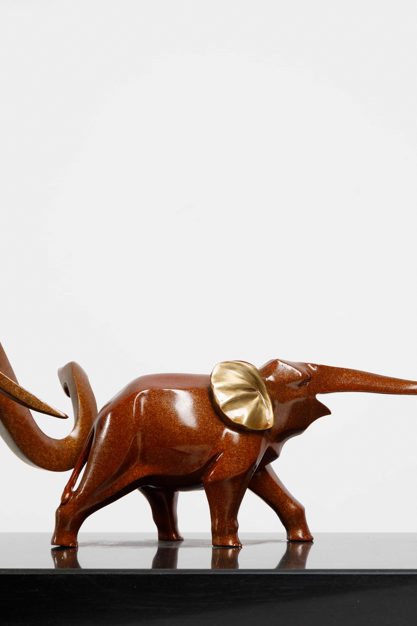 Mahogany-brown elephant family with gold ears — lead elephant close-up.