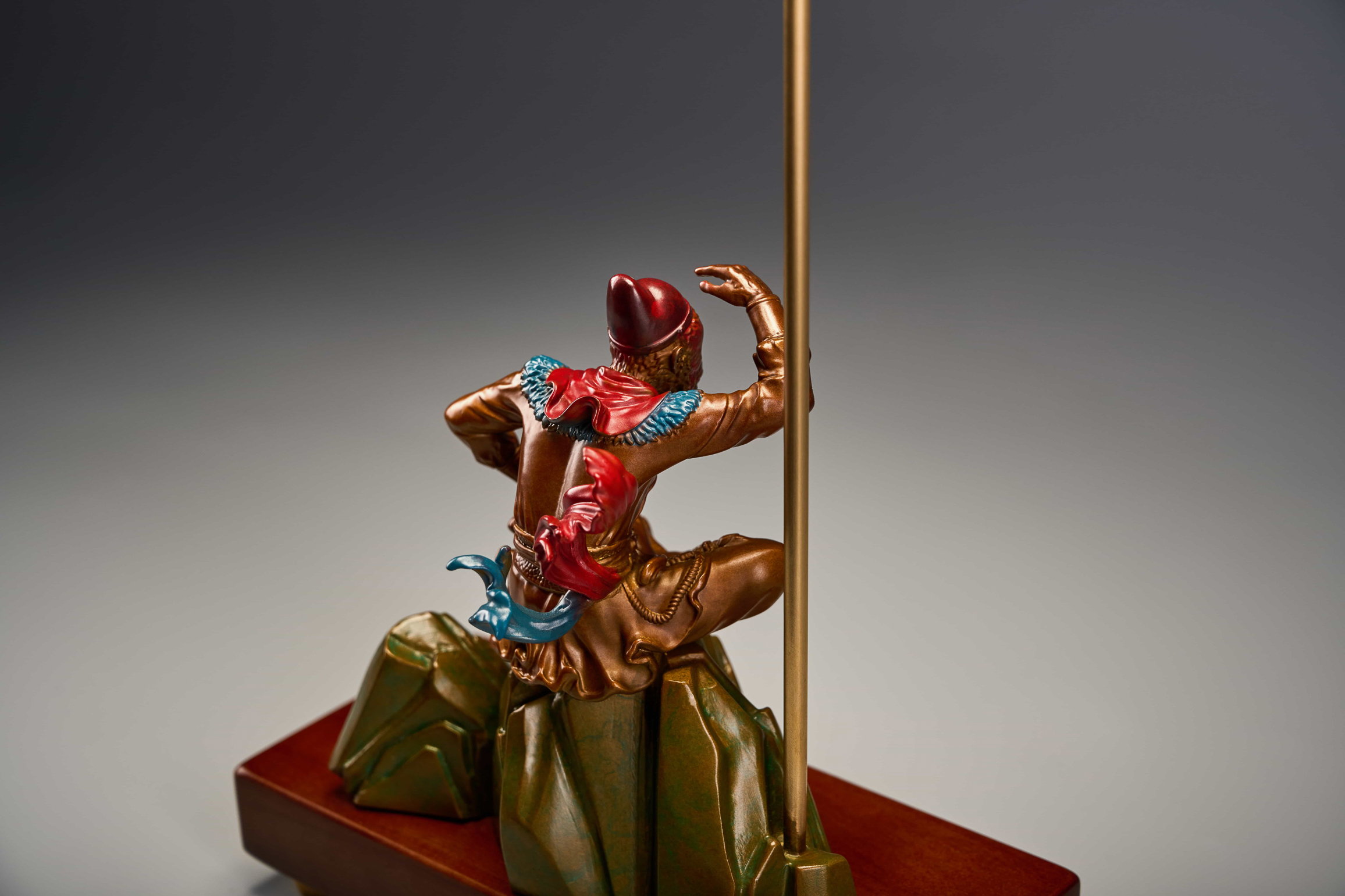 Enamel monkey king seated with golden staff — rear three-quarter.