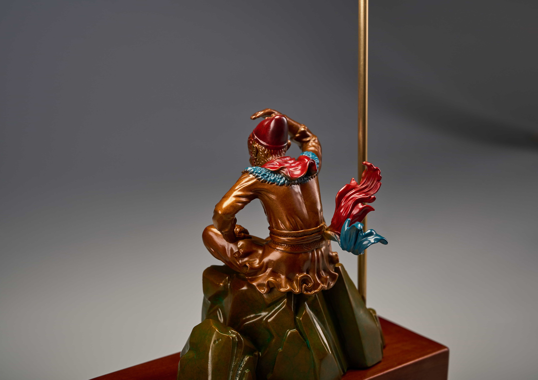 Enamel monkey king seated with golden staff — back detail.