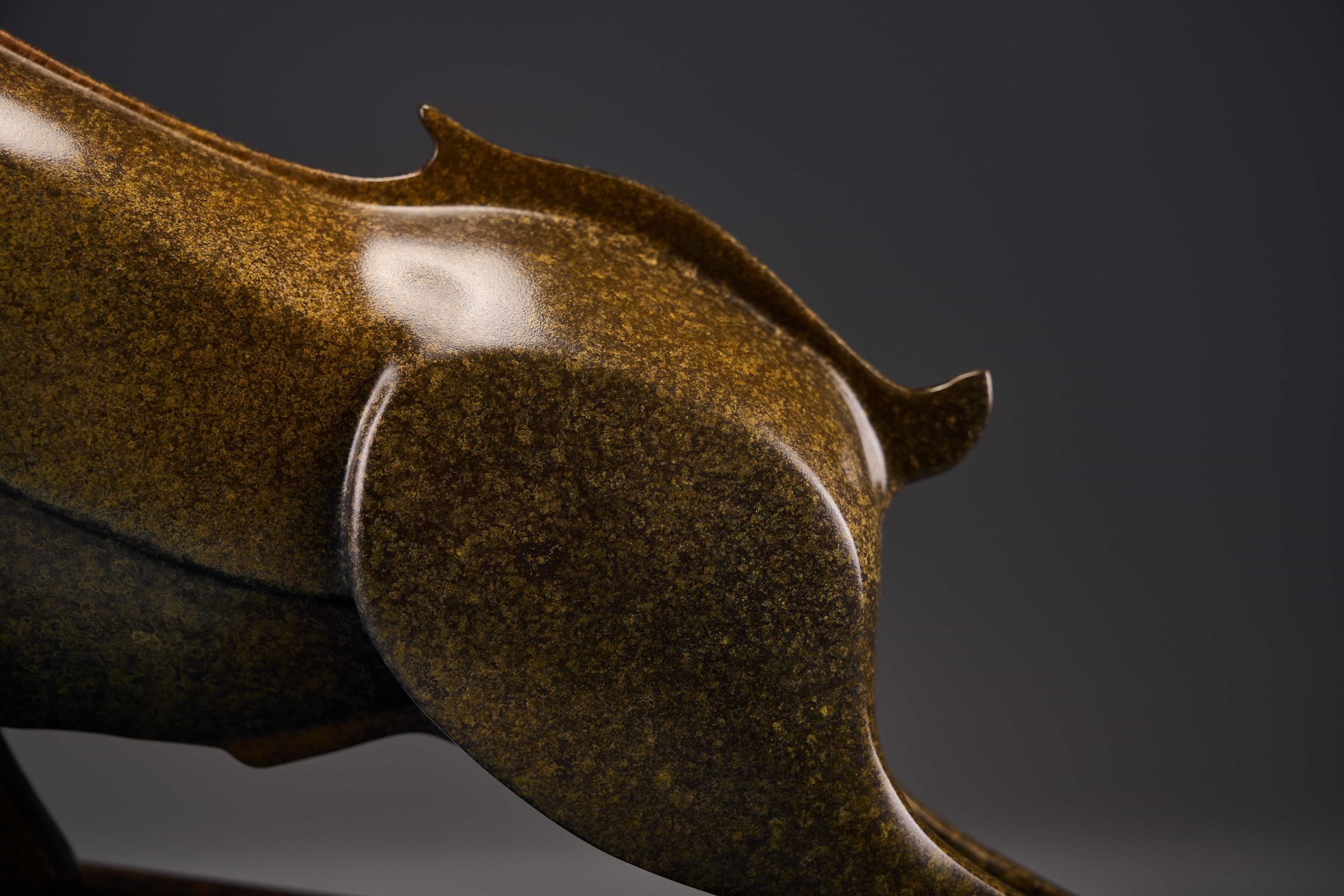Abstract charging bull with red crest — hindquarter detail.