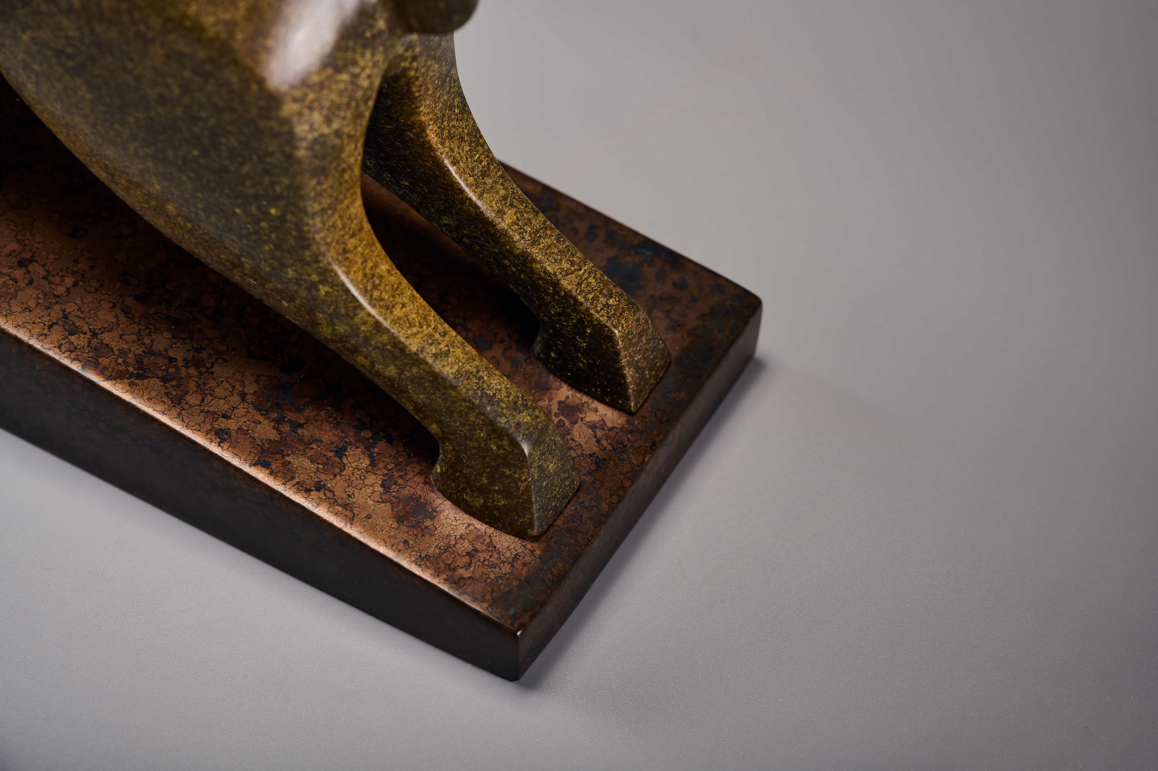 Abstract charging bull with red crest — legs and base detail.