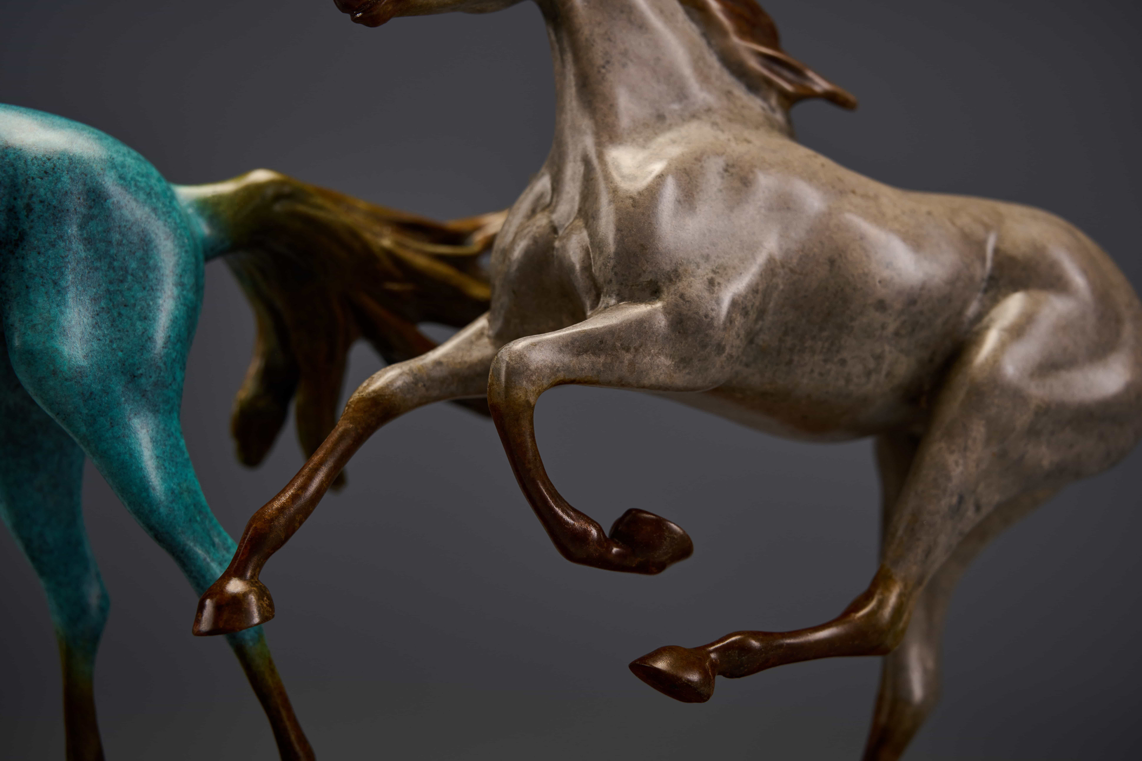Pair of chasing horses in turquoise and silver — legs close-up.