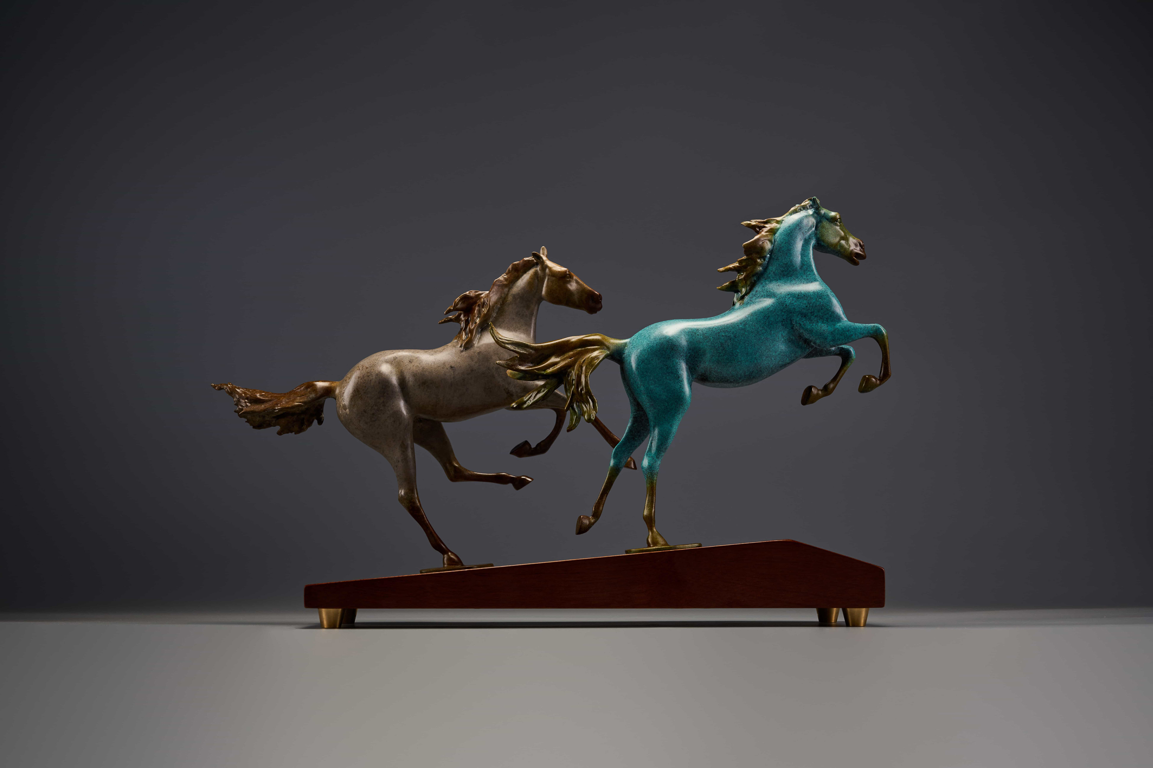 Pair of chasing horses in turquoise and silver — rear three-quarter.