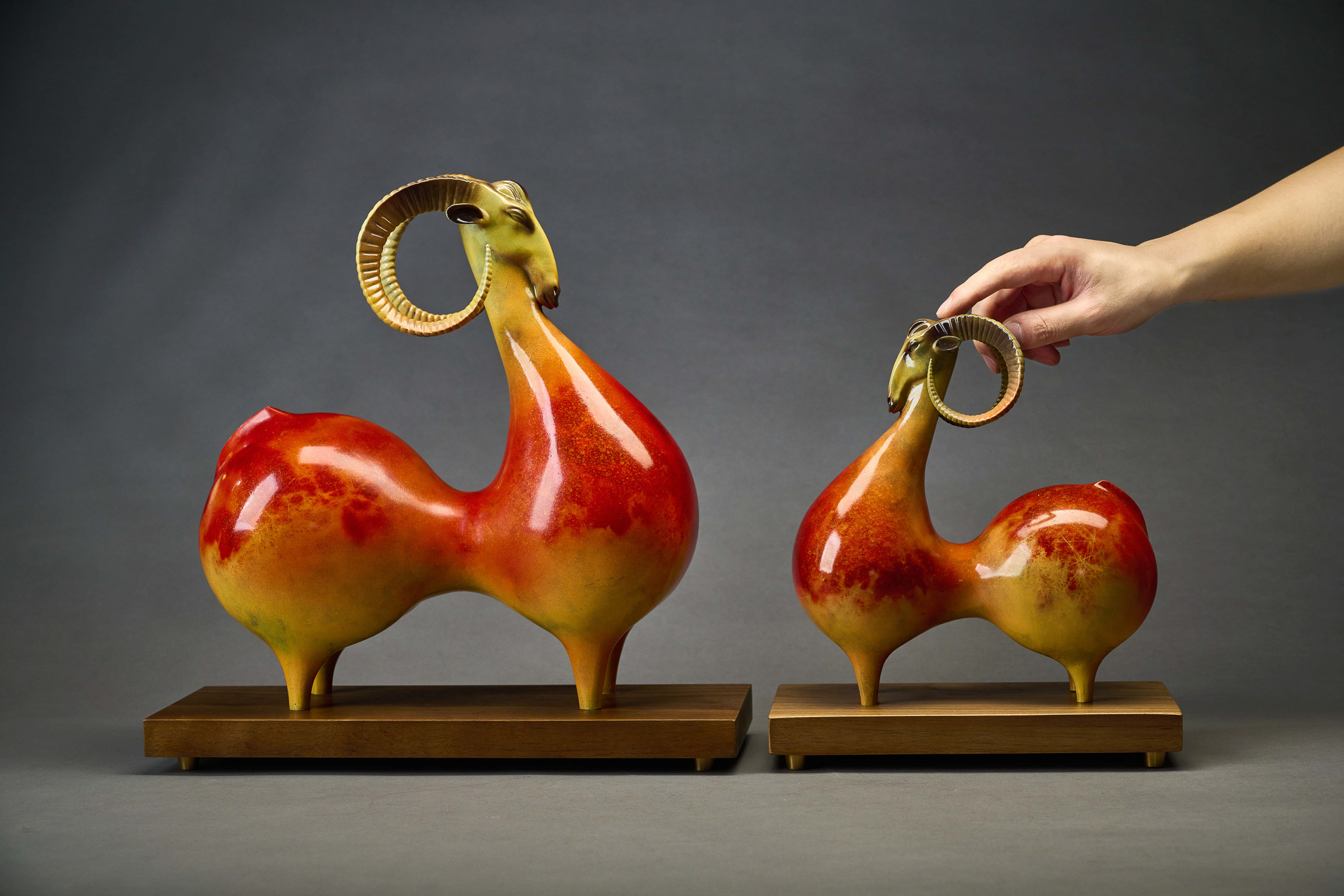 Red-and-gold argali ram with curled horns — size comparison with smaller variant.