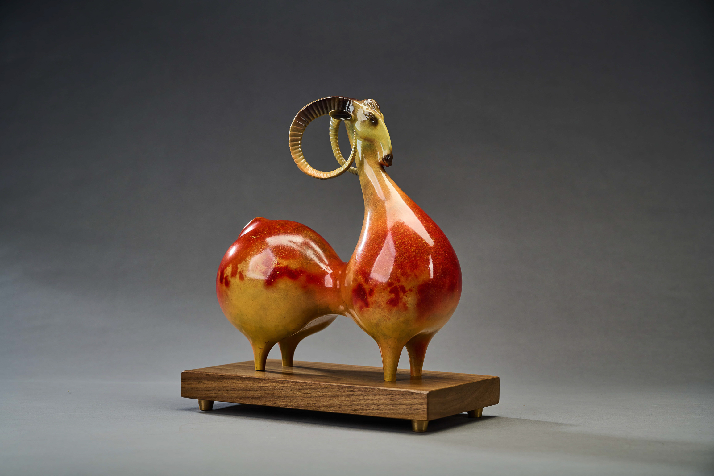 Red-and-gold argali ram with curled horns — rear three-quarter.