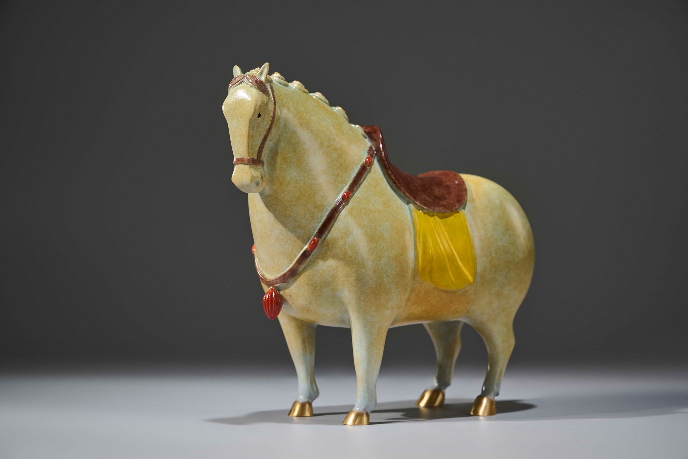 Celadon-glazed tang-style horse with red saddle — front three-quarter.