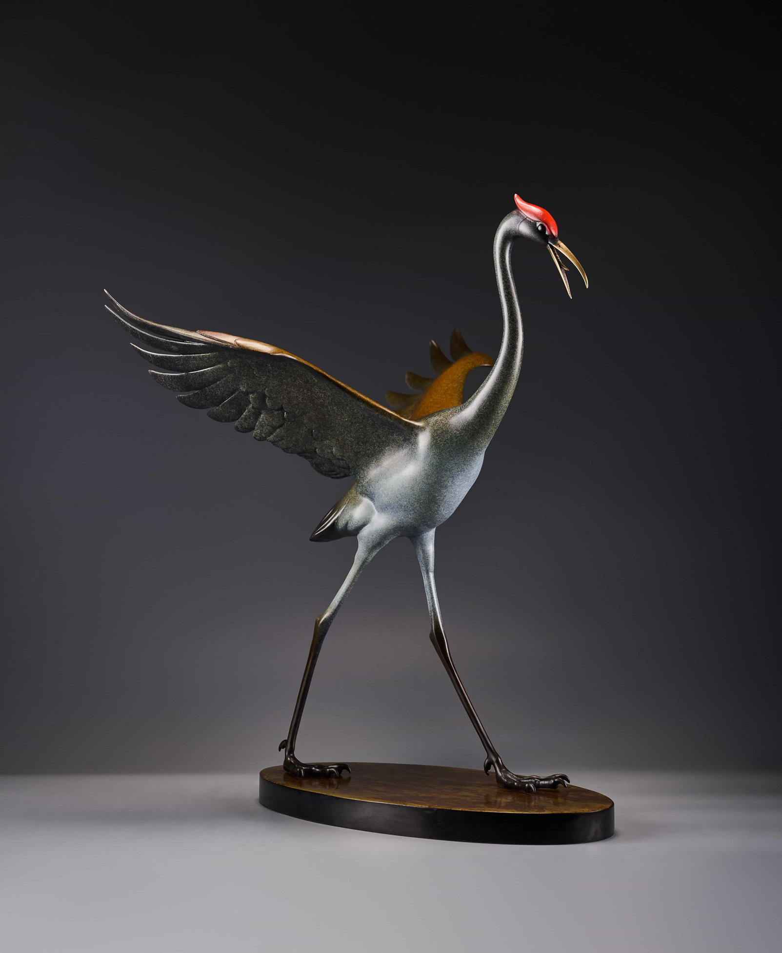 Silver crane with spread wings and red crown — front three-quarter.