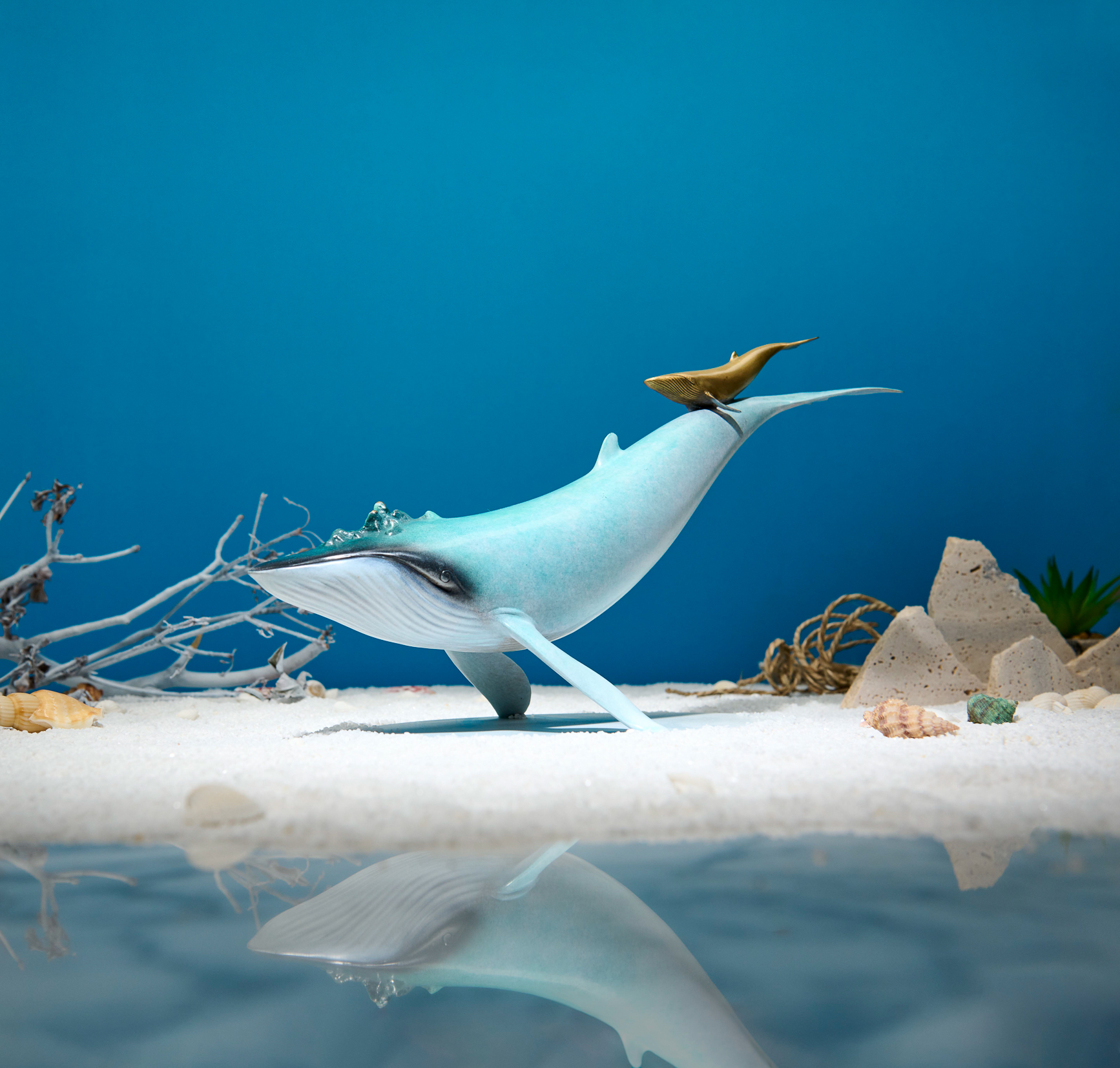 Blue-green whale with golden calf — seabed styled view.