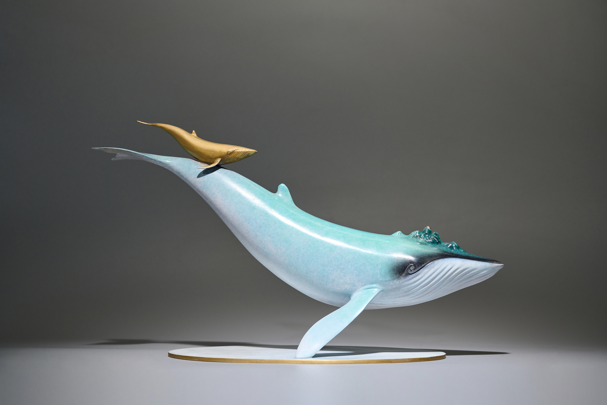 Blue-green whale with golden calf — mother and calf alt angle.
