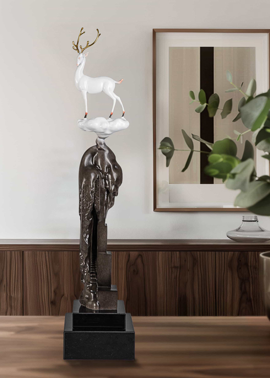 White deer on tall bronze cliff column — interior styled view.