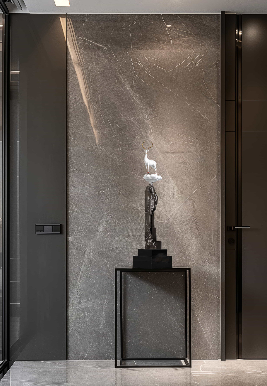 White deer on tall bronze cliff column — entryway styled view.