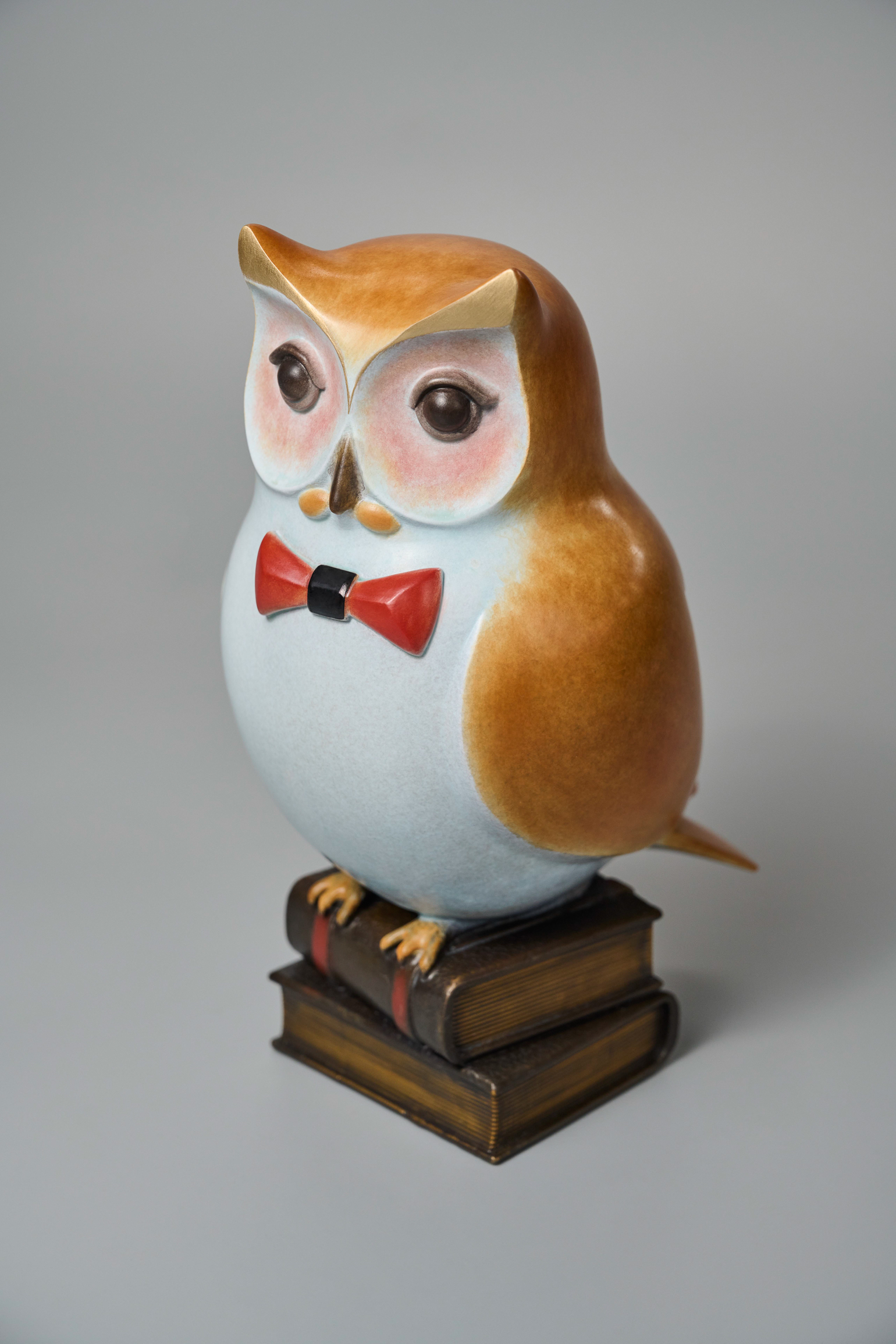 Cartoon owl with red bow tie on books — front lower angle.
