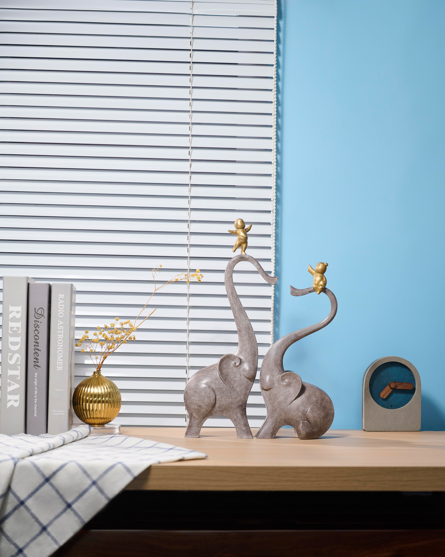Two elephants with golden figures on trunks — interior styled view.