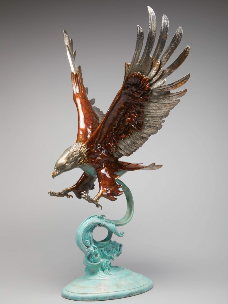 The eagle flew over the water, causing waves to rise.