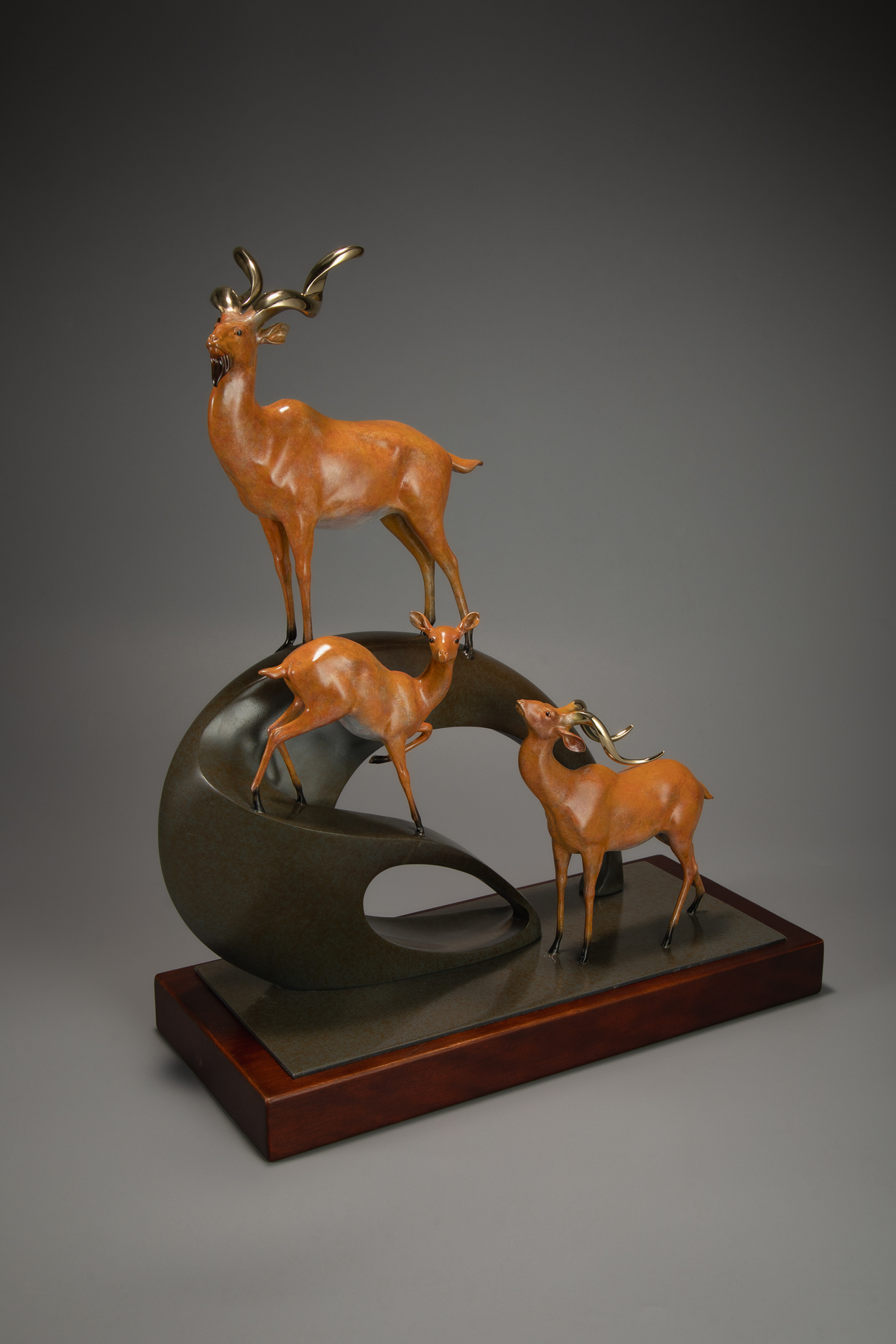 Golden antelope herd ascending arc base — wooden base view.