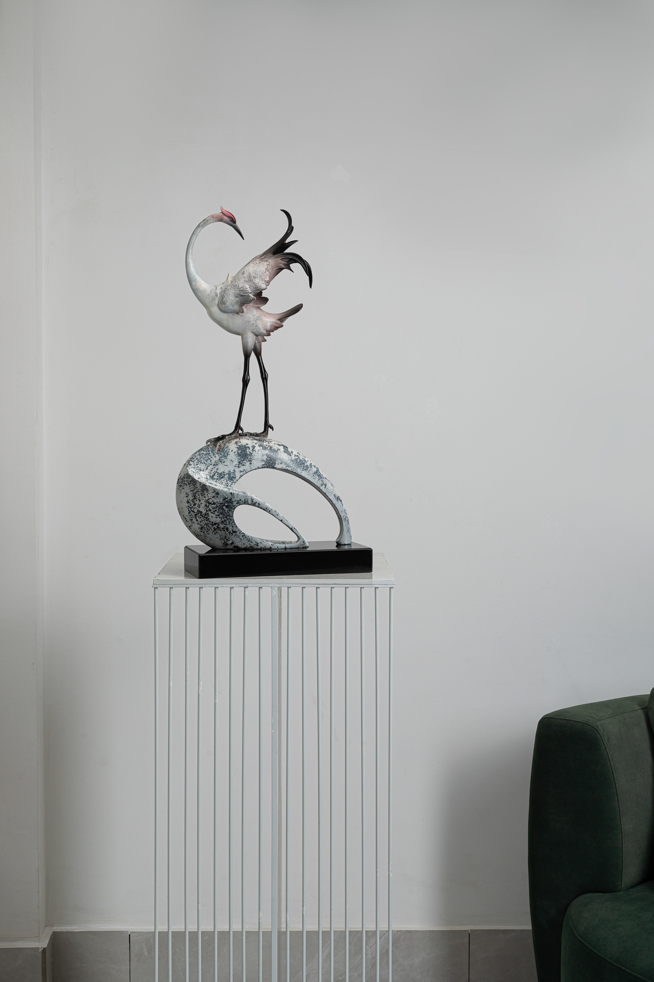 White crane preening on abstract ring base — interior view alt angle.