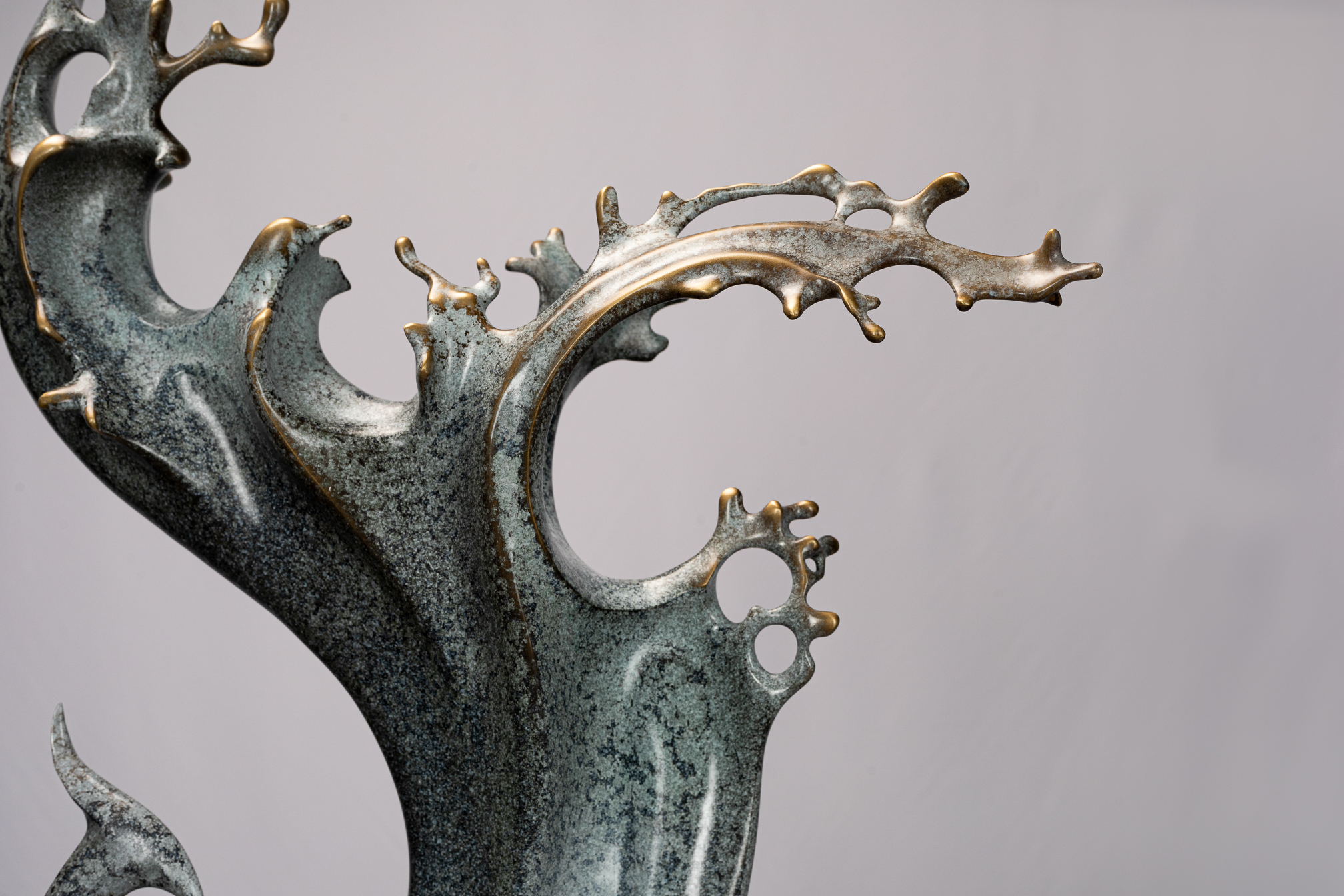 Abstract phoenix with flowing tail on black base — crown and wing tips close-up.